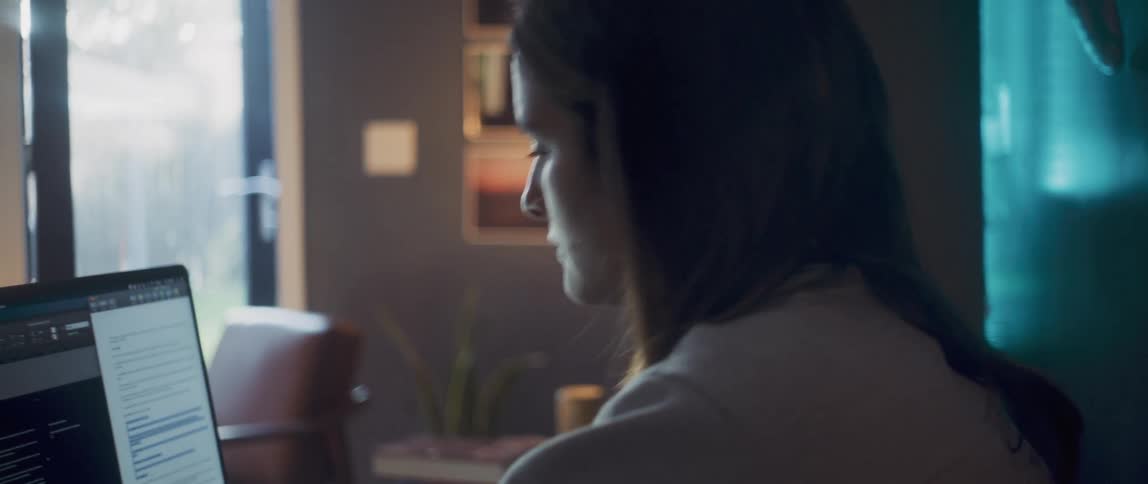 A woman is sitting in front of a laptop computer