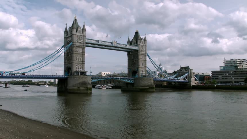 A bridge over a river with a bus crossing over it