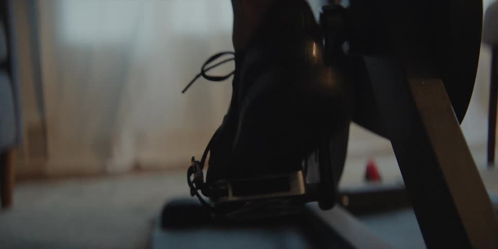 A person gets on the exercise bike and begins pedaling