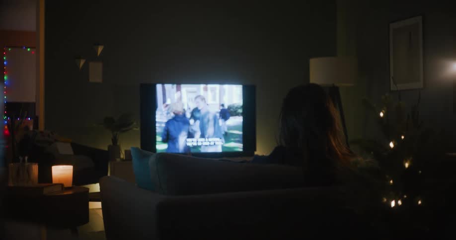 A woman is watching the television