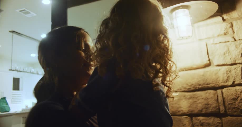 A woman holds her child in the back yard