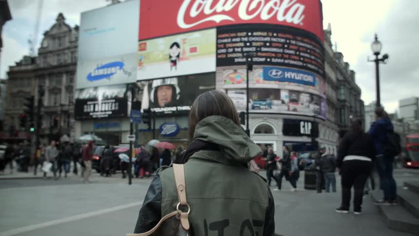 A city square is filled with people and signs