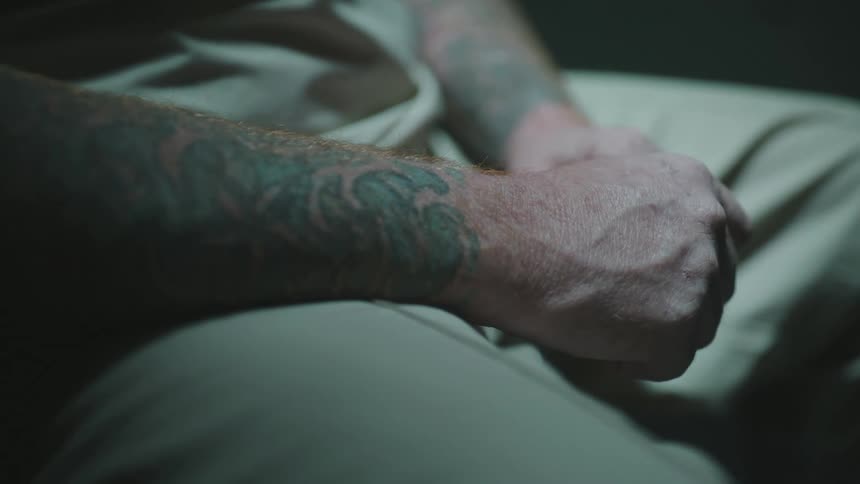 A prisoner has tattoos on his arms