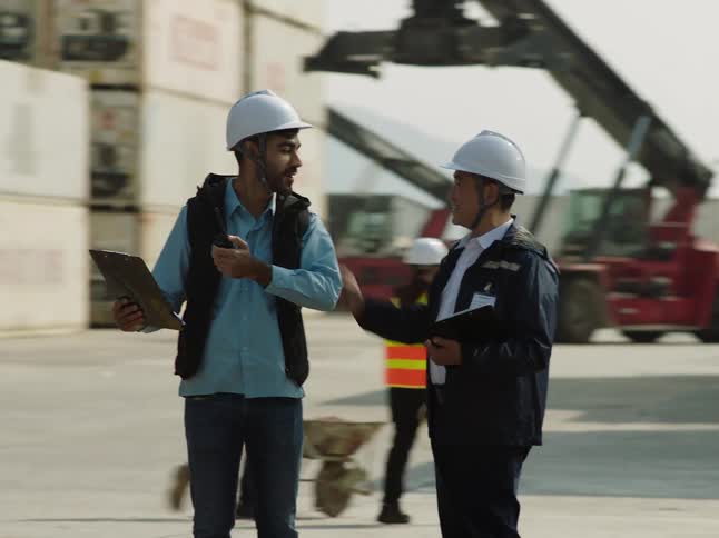 A man congratulates an employee at a ship yard
