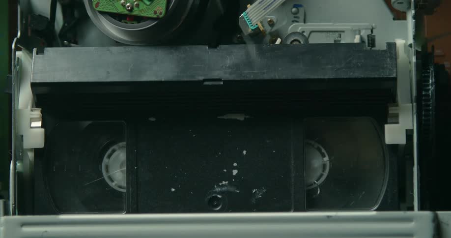 An old video tape is spinning in a machine