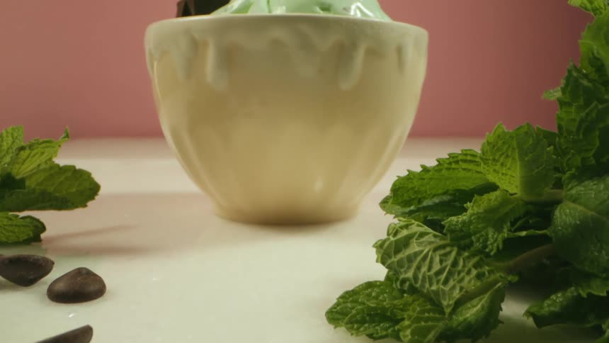 Ice cream bowl with pieces of chocolate on a white table in a photography studio