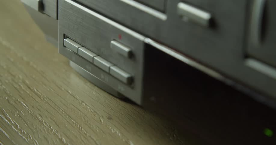 A person pushes a button on a stereo system