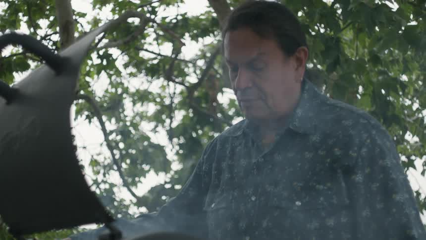 A man is grilling outdoors during the spring time