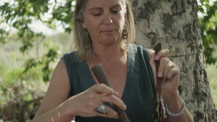 A woman is preparing a meal outdoors at a picnic table