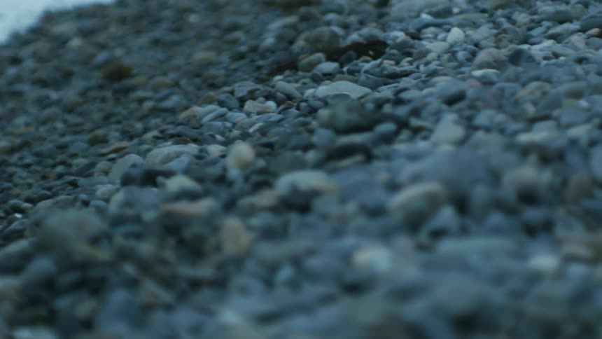 Close up view of ocean waves and rocks on the beach is displayed