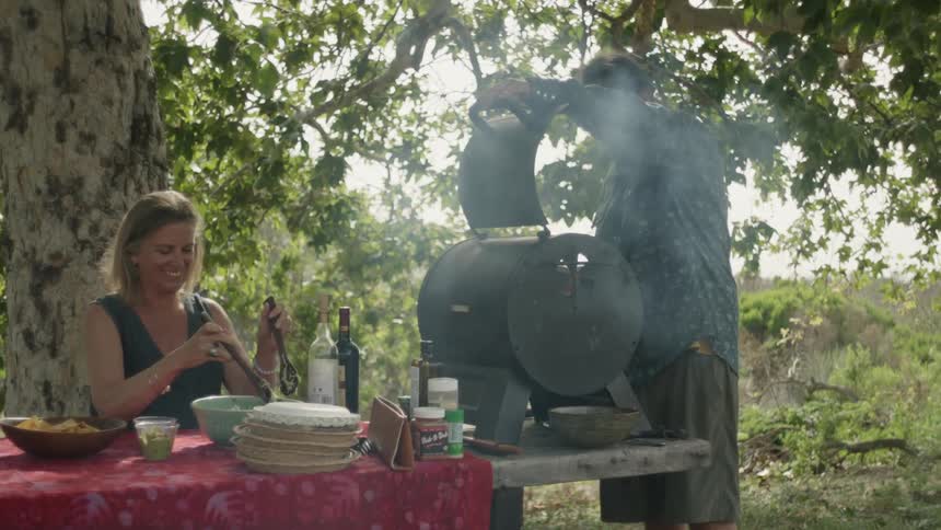 A man and woman grilling outdoors