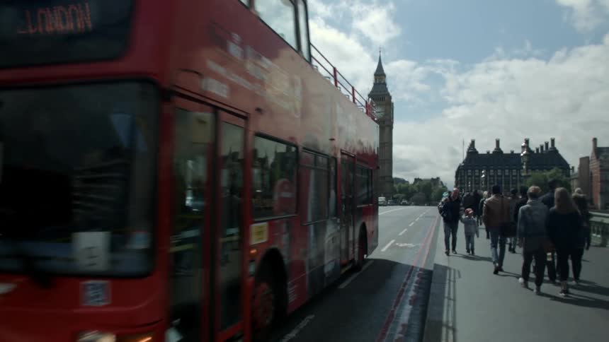 Vehicles and people travel down a city bridge