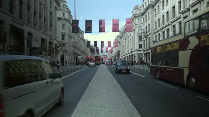 A city street has traffic and people traveling in both directions