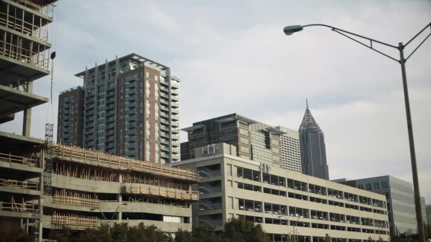 Moving past rows of buildings on a cloudy day