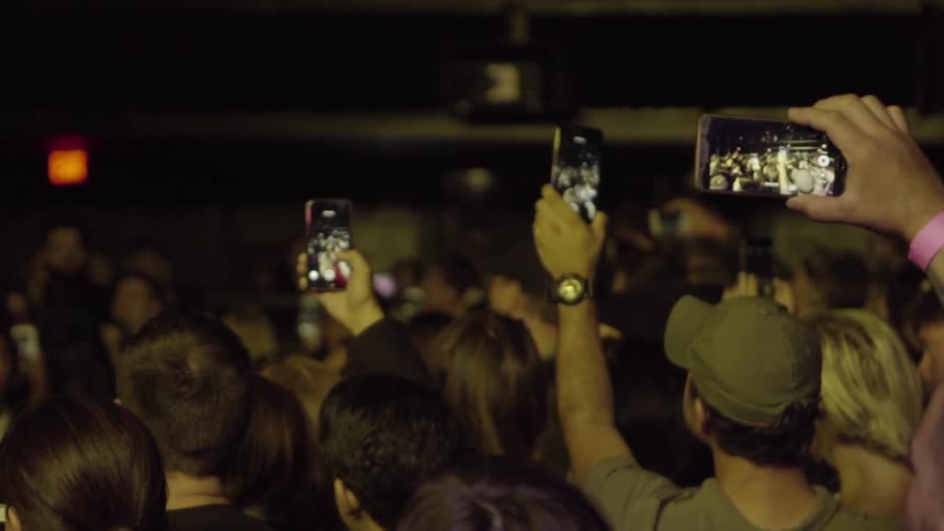 A crowd of people, some filming
