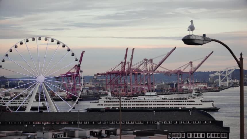 A ship sails near a rotating ferris wheel
