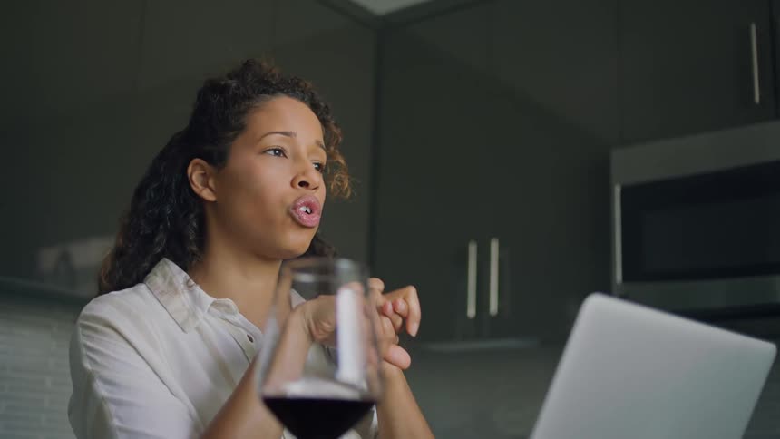 A woman talks on her laptop in the kitchen