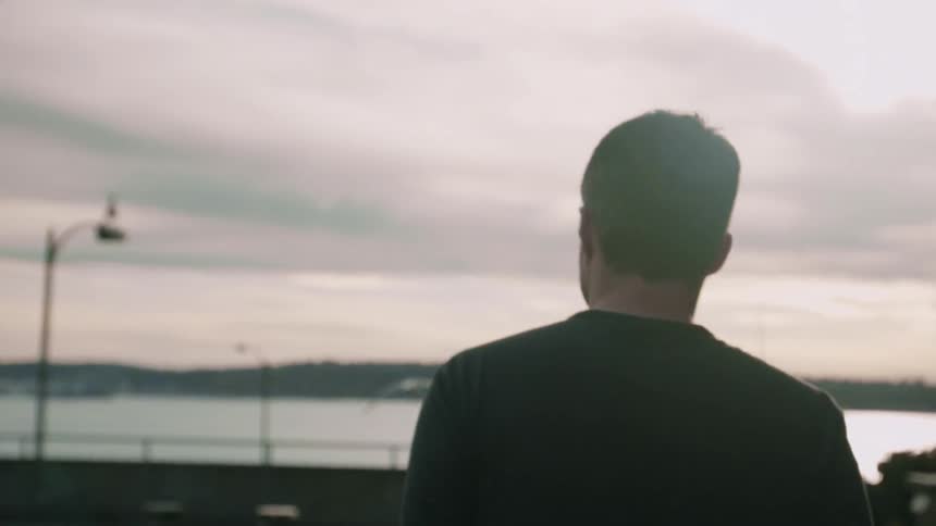 A man is walking outside near the boardwalk