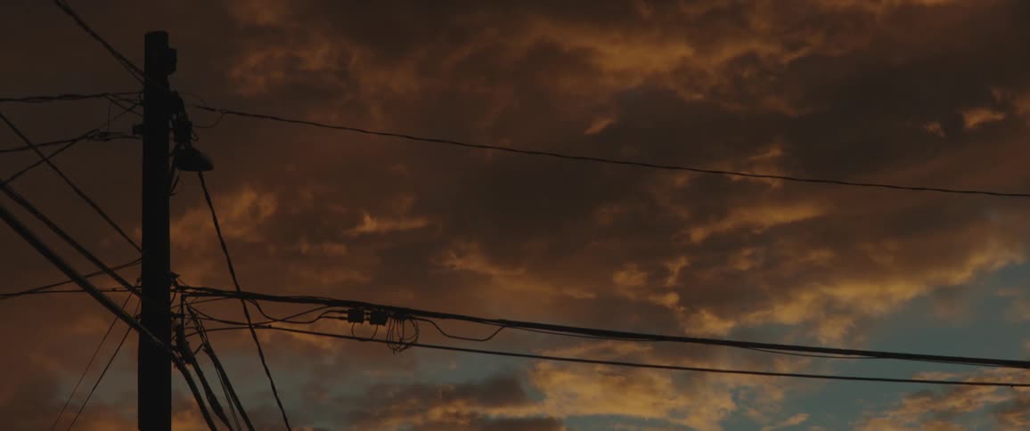 The power lines are by the large clouds
