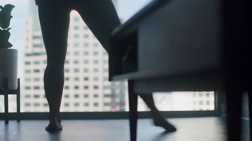 A woman dances around her apartment