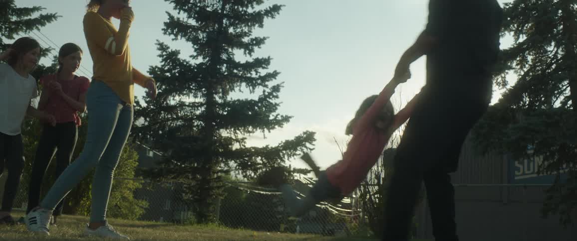 A man plays with his daughters in their backyard