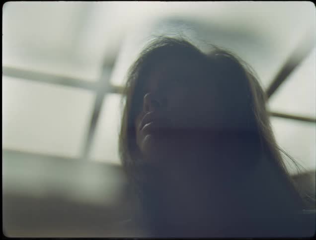 Woman briefly stands still in shadow before moving