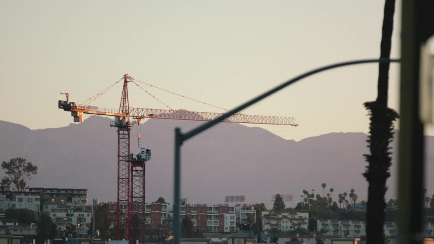 A construction crane by a row of apartment buildings
