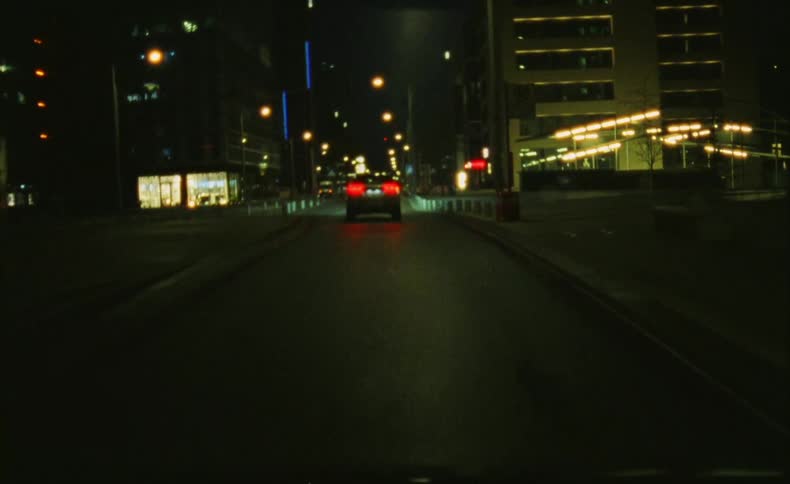 A car drives through the city at night