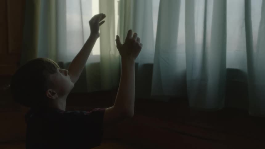 A boy is tossing a football in the air