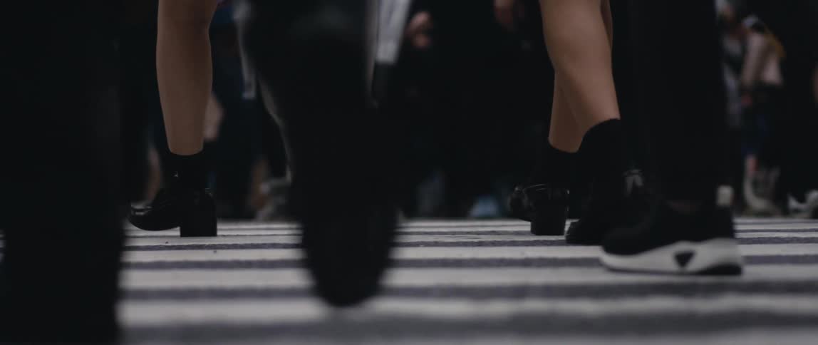 A large crowd of people walking across a street