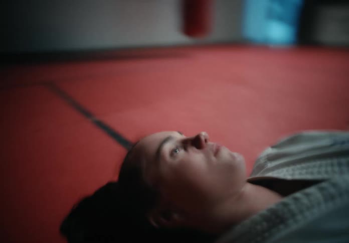 A girl is laying on the mat in the gym