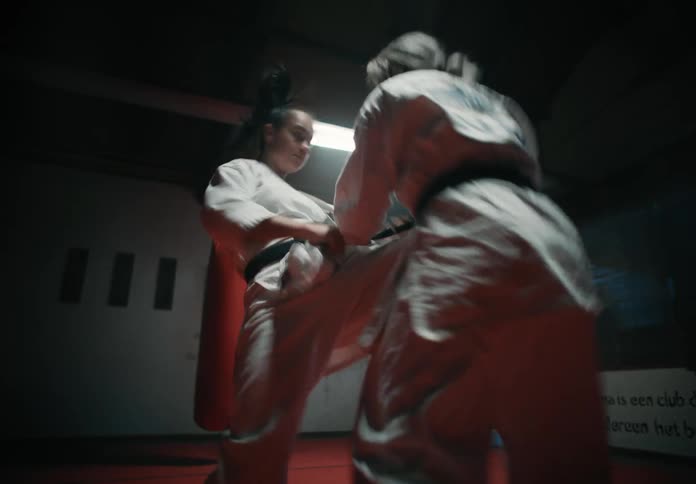 Two young women spar in a karate match