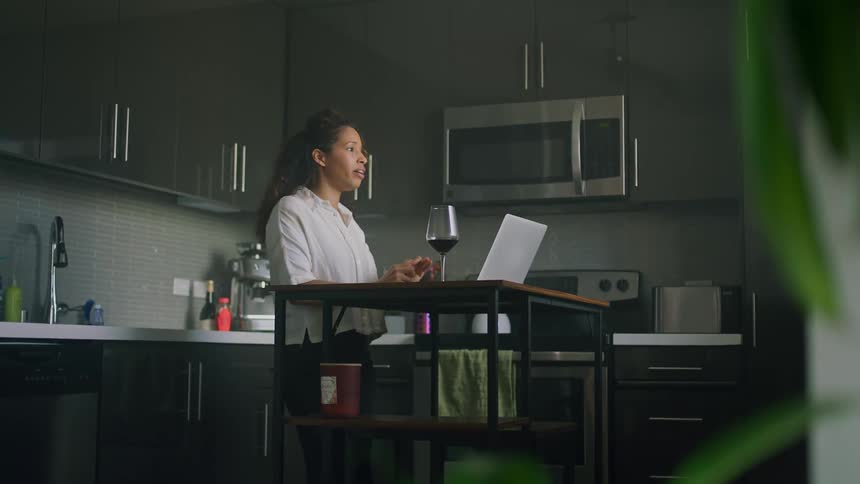 A woman is talking to someone on a laptop