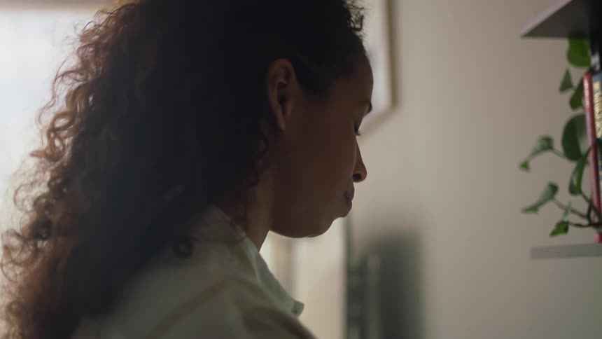 A woman is standing alone in her house