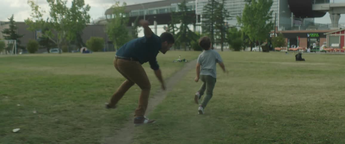 Father and son are playing outdoors at a park during spring time