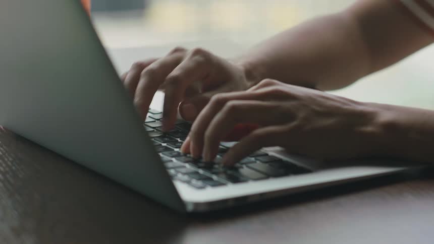Person sits typing on laptop