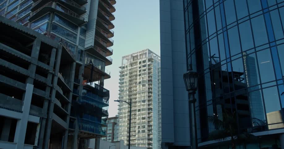 A building facade reflects the surrounding unfinished construction on a city street