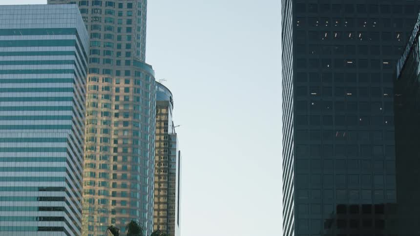 Traffic flows down city street between downtown skyscrapers