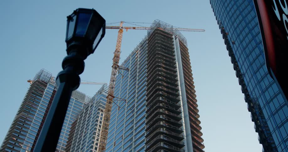 A skyscraper being constructed in a metropolis under a clear daytime sky
