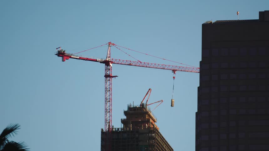 A construction crane is set up near a tall building