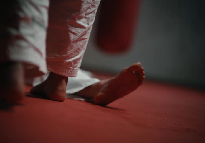 As two martial artists fight one kicks the other making them fall