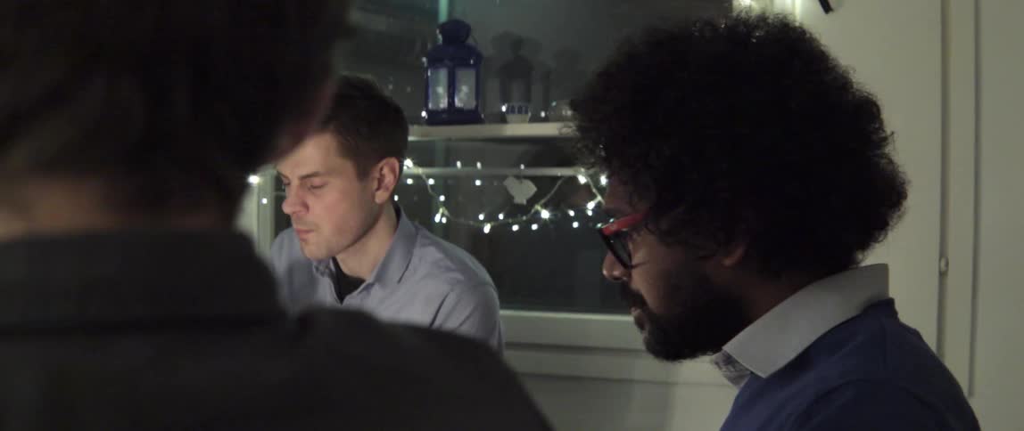 A group of men interacting at a diner table at night
