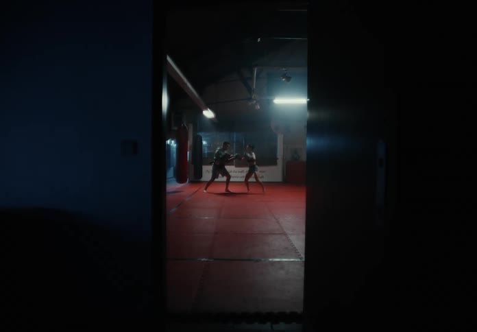 Trainer and female fighter train in the gym
