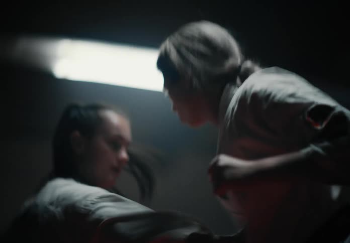 Two female martial artists wearing martial art uniforms fight