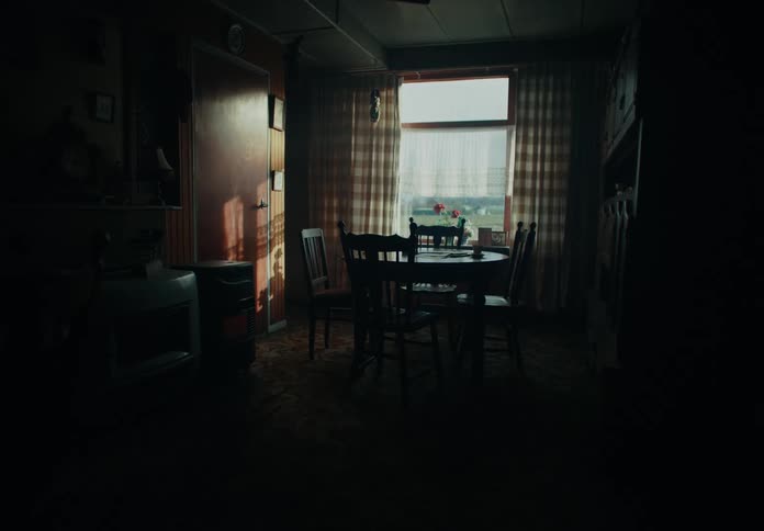 A round table with four chairs sits near a window in a room