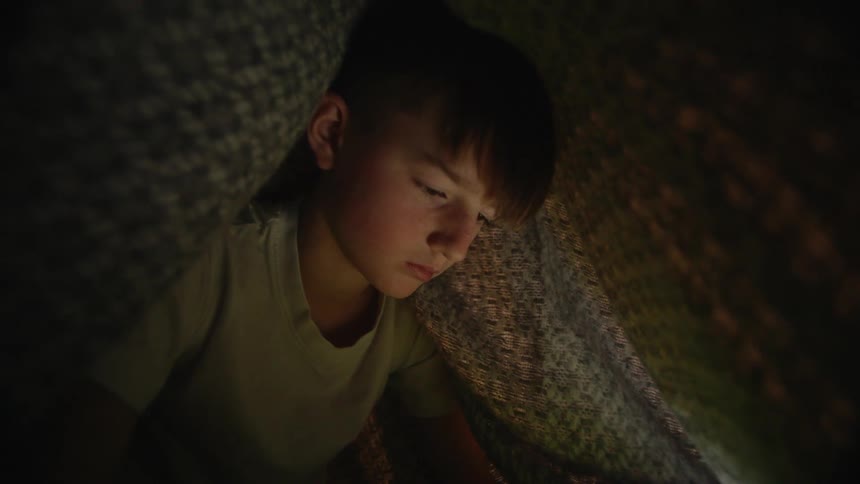 A child is under a blanket tent