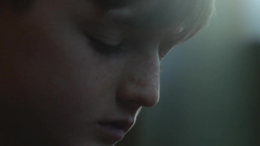 A boy is holding a football indoors