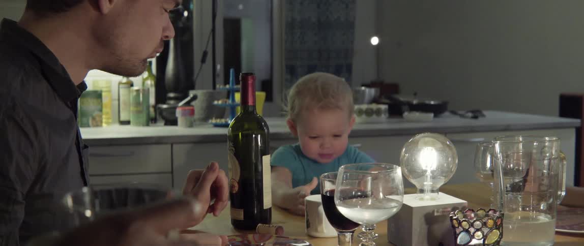 Family smiling and laughing together while enjoying dinner at home table