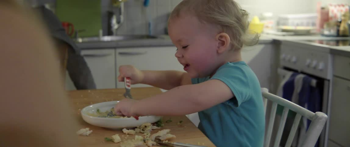 Messy young child having a tantrum and throwing food at a festive family meal gathering