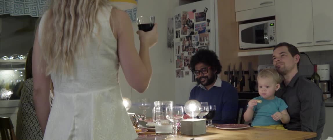 Friends and family enjoying a lively dinner party with food and laughter